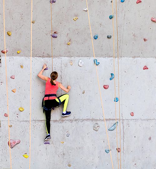 vrouw beklimt indoor klimwand